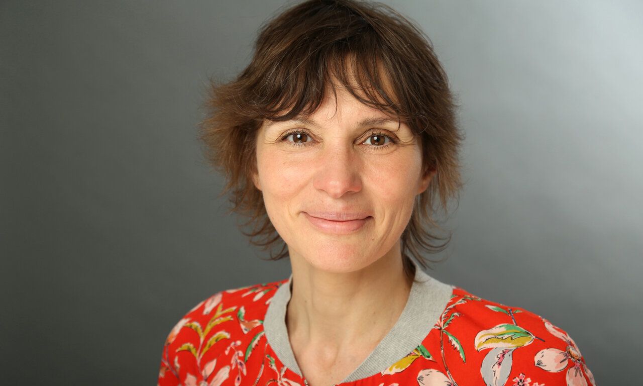 Porträtfoto von Julia Bonk vor grauem Hintergrund