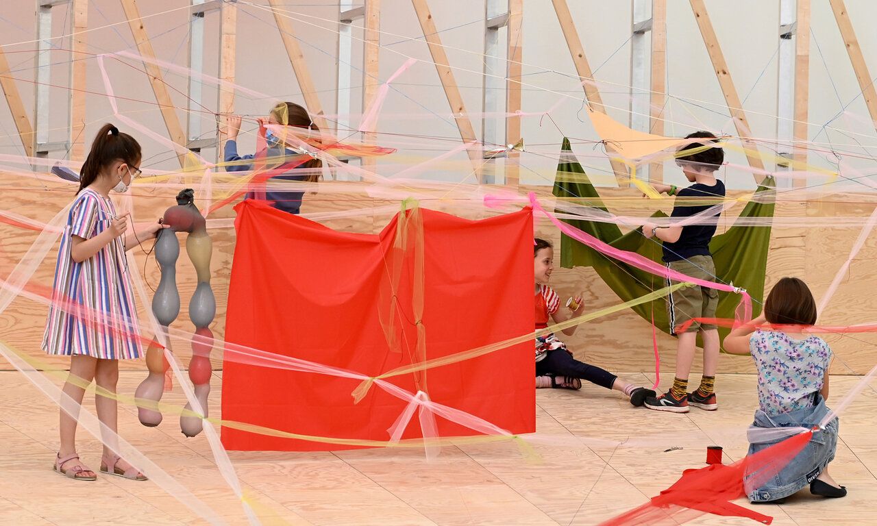 Kinder in einer Rauminstallation aus Holz und Stoff