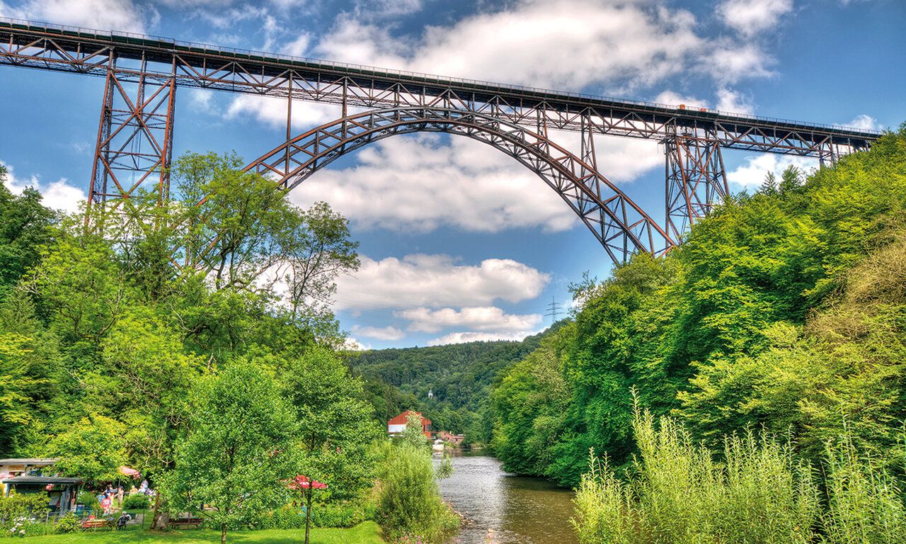 Die Müngstener Brücke von unten mit Wupper und Landschaft
