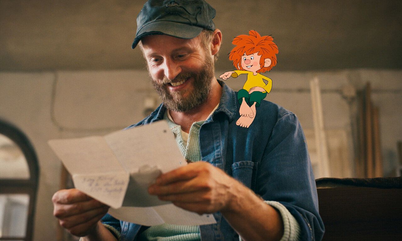 Szene aus dem Film Pumuckl und das große Missverständnis, Meister Eder liest einen Brief und Pumuckl sitzt auf seiner Schulder