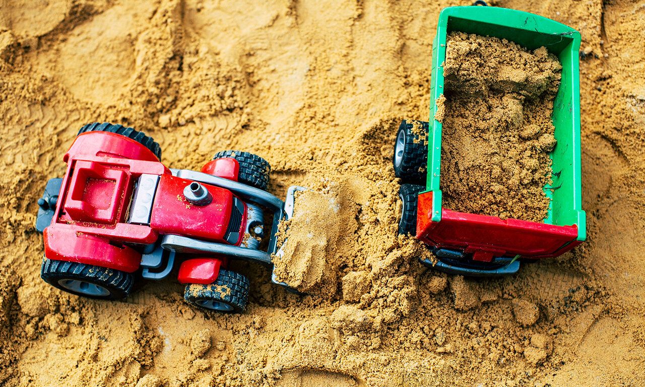 Sandspielzeug im Sand von oben fotografiert