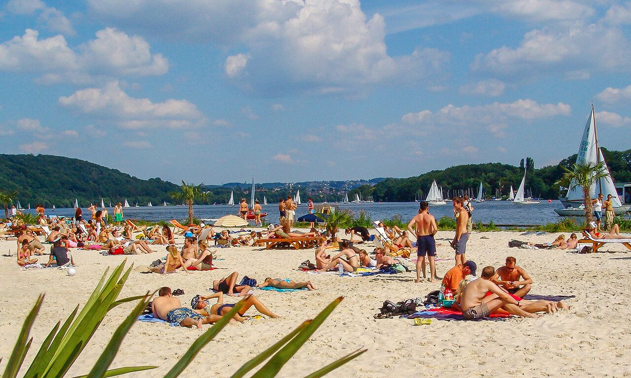 Leute liegen am Strand vom Baldeney See