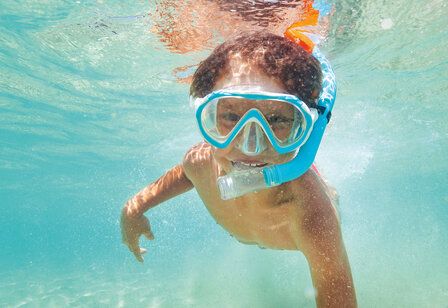 Unterwasseraufnahme von einem Kind mit Taucherbrille