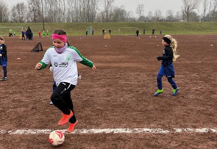 Mädchen trainieren Fußball auf einem Ascheplatz