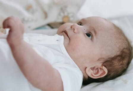 Baby liegt auf dem Rücken und guckt nach oben