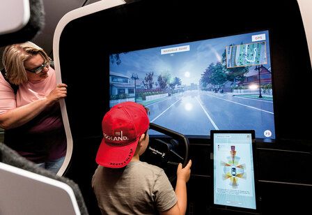 Junge sitzt an einem Fahr-Simulator