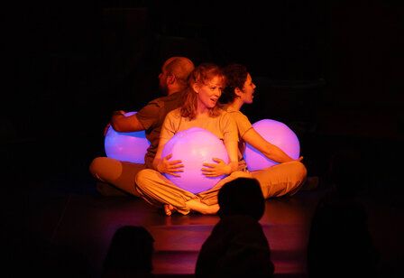 Familienmusikwoche Himmelblau, drei Personen mit rosa Wasserbällen auf der dunklen Bühne