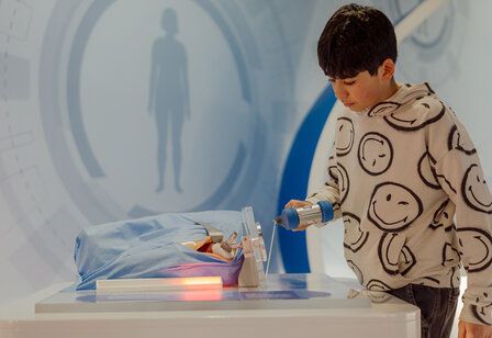 Junge an einer interaktiver Station der MS Wissenschaft