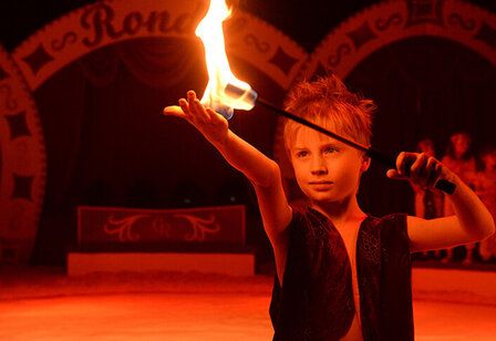 Junge mit Feuerstab im Winterzirkus