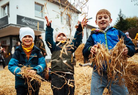 Jungs spielen mit Heu auf dem Martinsmarkt in Monheim