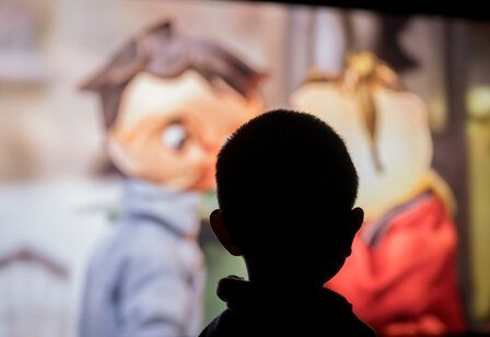 Kikife Silhouette eines Kinderkopfes vor Kino-Leinwand
