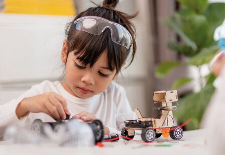 Mädchen beim Coding von kleinen Roboter-Autos