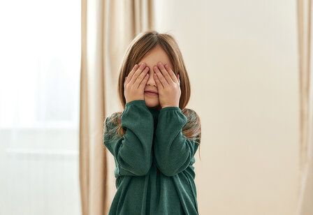 Mädchen hält sich die Augen zu