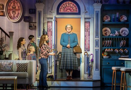 Szene aus dem Musical Mrs Doubtfire, Mrs Doubtfire steht in der Haustür und wird von der Familie begrüßt