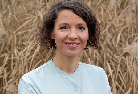 Porträt Claudia Trinks, im Hintergrund ein Getreidefeld