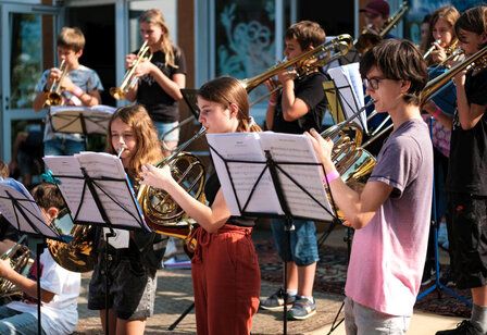 Jugendliche musizieren mit Blasinstrumenten