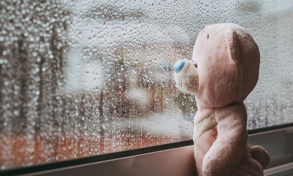Trauriger Teddybär am Fenster Regen
