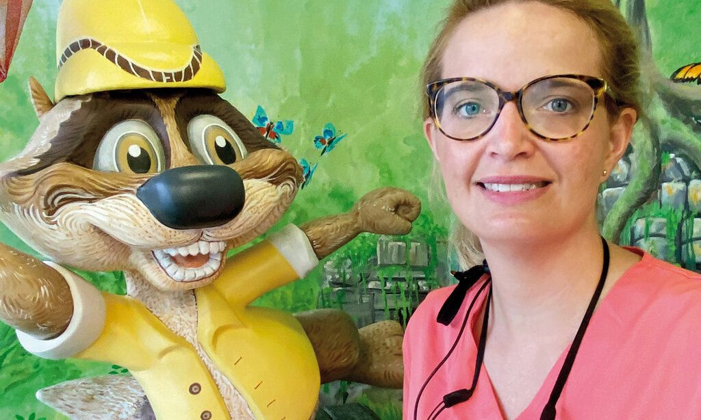 Zahnärztin Anna Katharina Kreienkamp mit lustiger Biberfigur vor grüner Wand