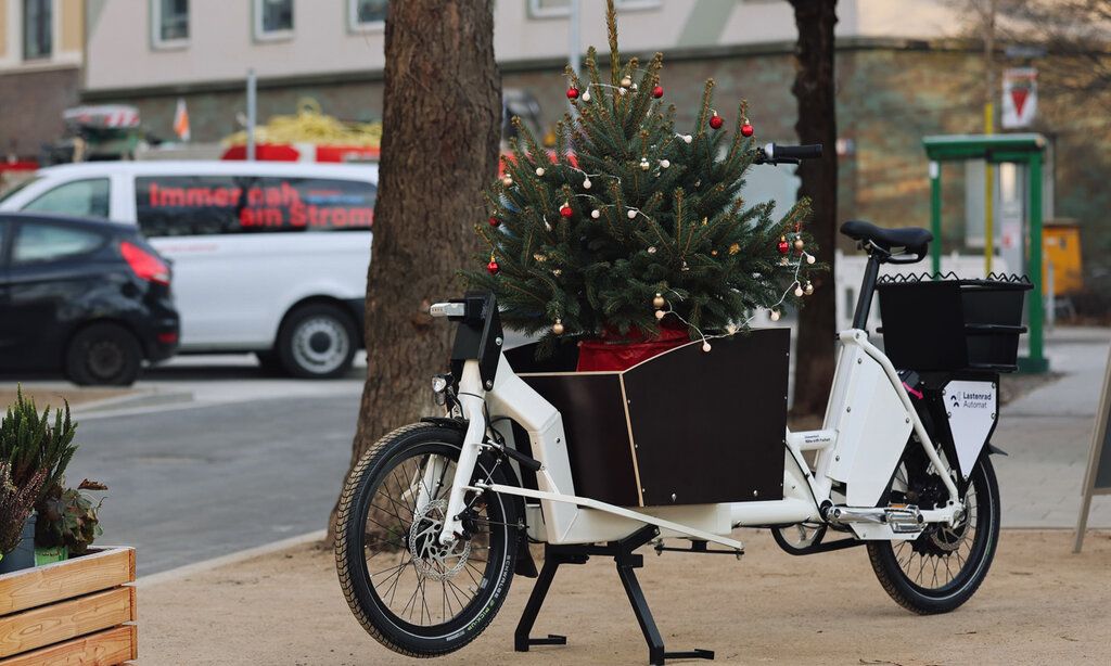 ein Lastenfahrrad  mit einem Weihnachtsbaum in der Transportkiste steht auf einem Platz in Düsseldorf