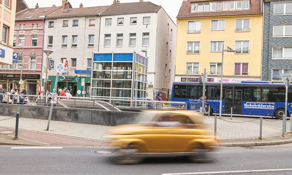 Kölner Straße in Düsseldorf-Oberbilk, ein Auto fährt mit Bewegungsunschärfe durchs Bild