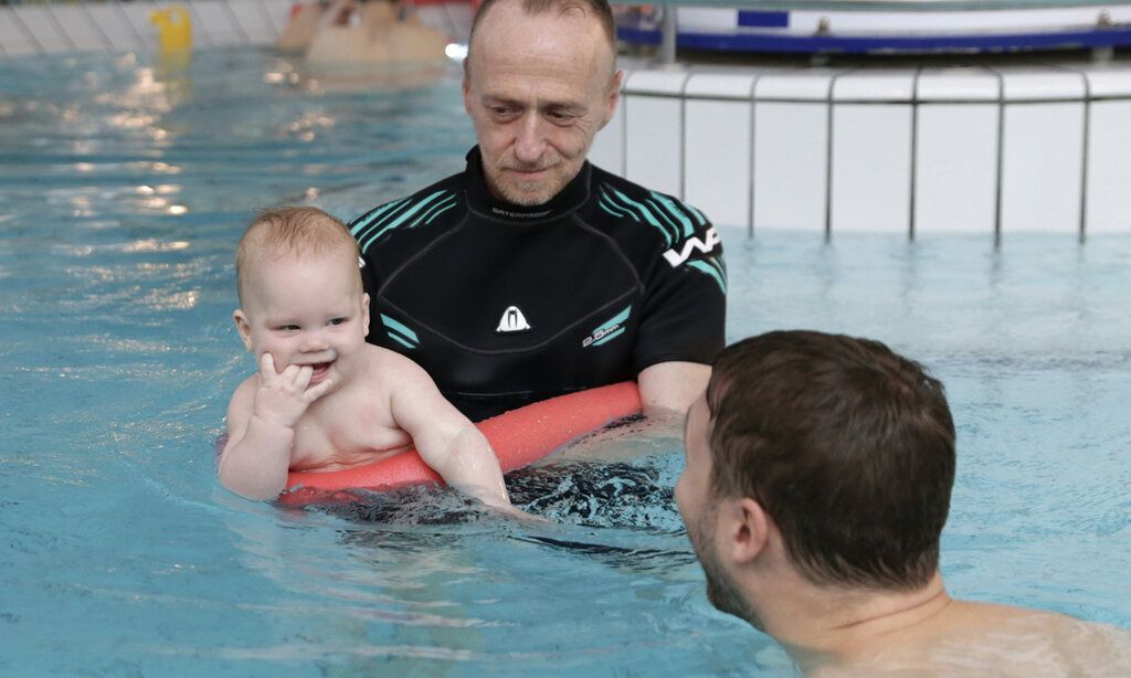 Schwimmtrainer Siegfried Jurcic mit Just und seinem Vater Jannis Rorarius