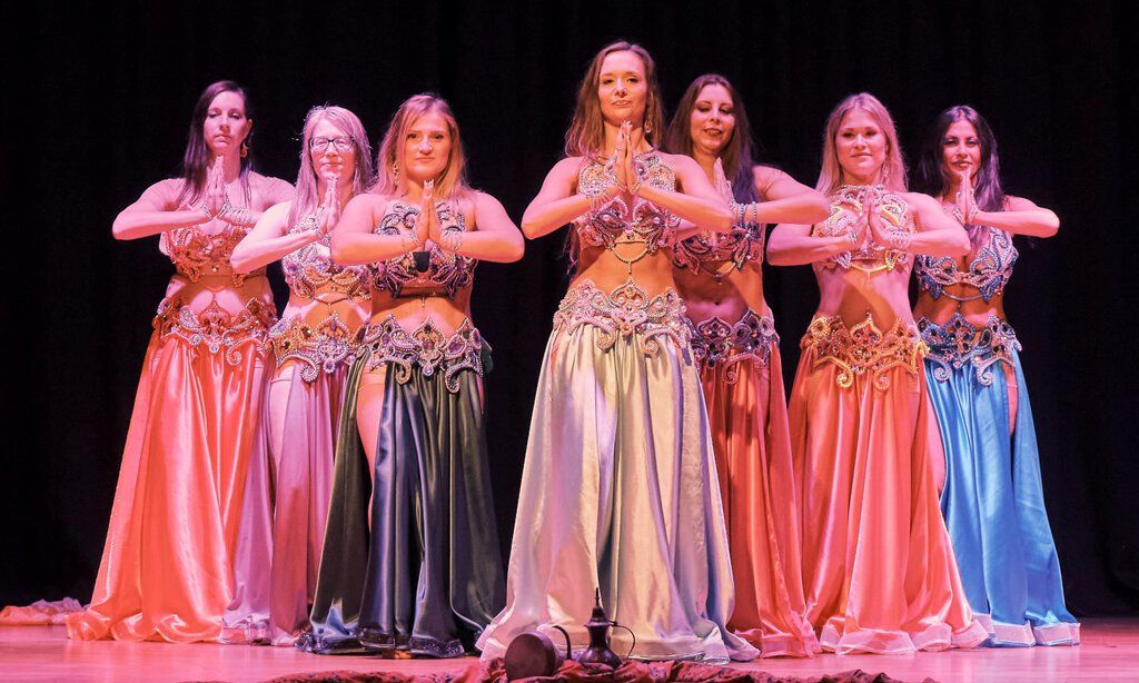 Eine Gruppe von Frauen zeigt einen orientalischen Bauchtanz auf einer Bühne.
