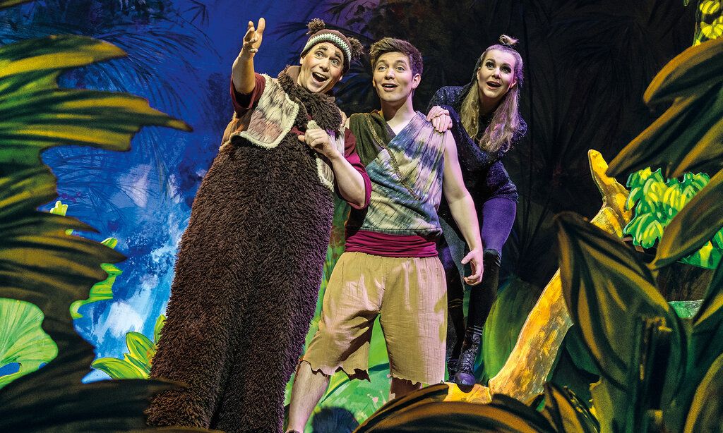 Szene aus dem Theaterstück, eine Figur deutet auf etwas, zwei andere folgen mit ihrem Blick