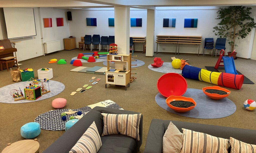 Spielbereich beim Elterncafé der Rheinkirche mit Sofas und verschiedenen Spielzeugen..