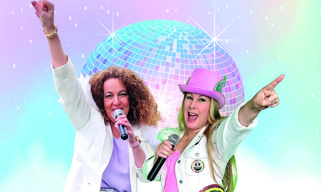 Beide Sängerinnen der Band GroßstadtEngel posieren mit Mikro vor einer Discokugel