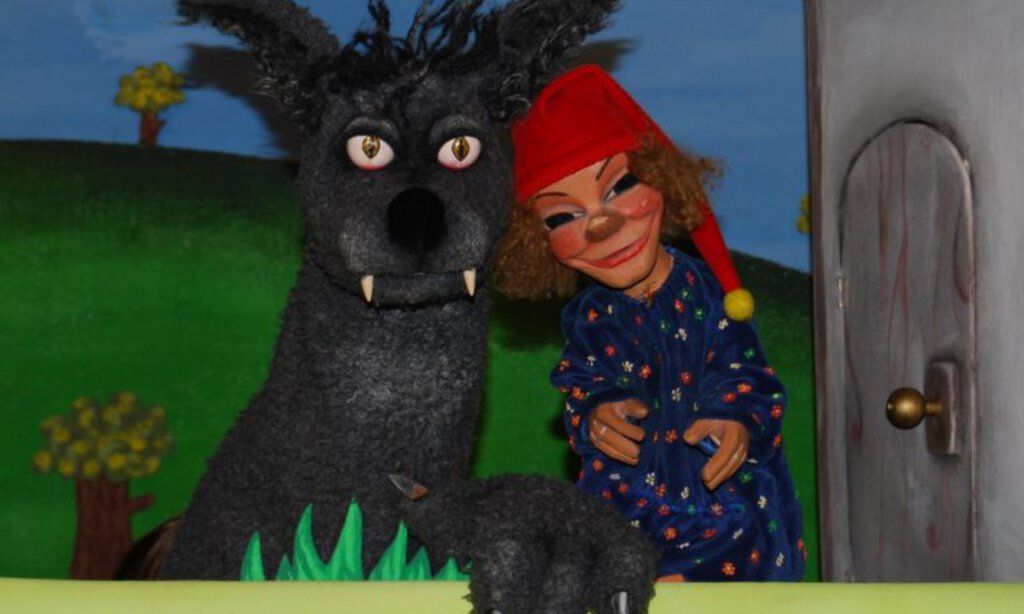 Die Puppen von Kasper und der Wolf vor der Puppenspielbühne