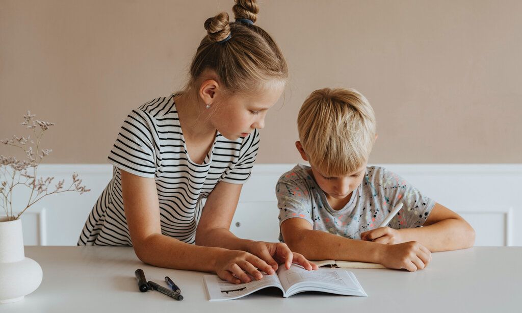 Mädchen und Junge machen Hausaufgaben