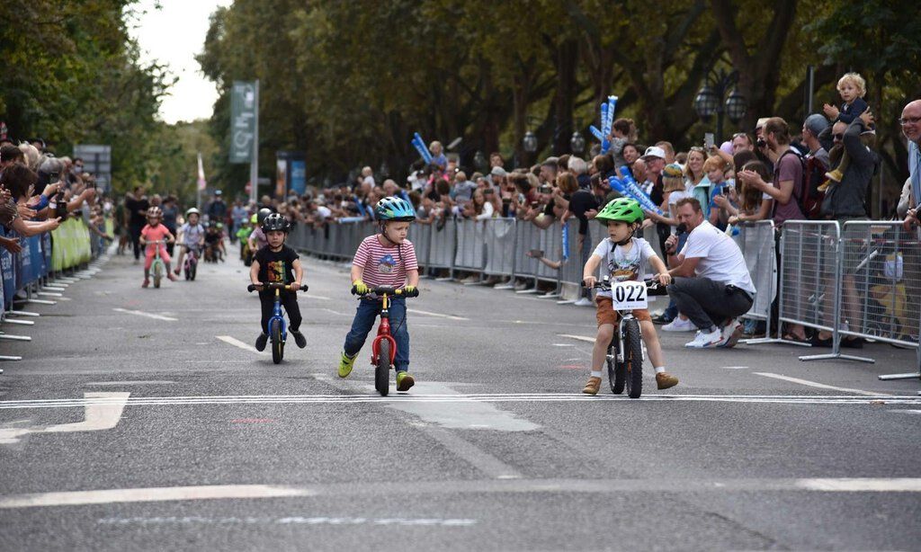 Kleine Kinder fahren auf ihren Laufrädern beim Radrennen „Rund um die Kö“ um die Wette