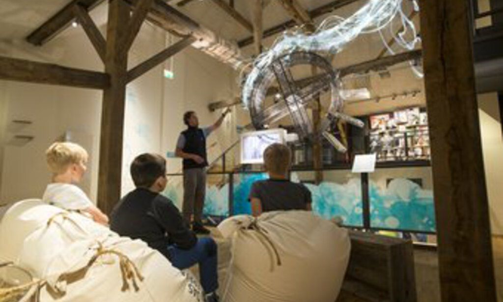 Kinder im KM51 – Das Erftmuseum hören dem Museumsführer zu.