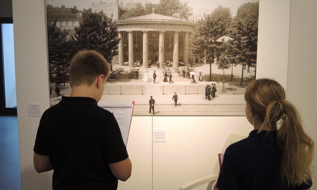 Zwei Kinder betrachten ein Foto in der Ausstellung der Römerthermen Zülpich