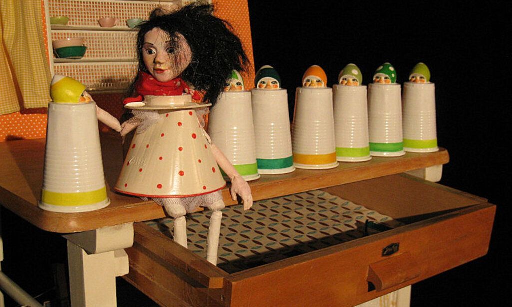 Bühnenbild von „Schneewittchen“, gespielt vom Theater Fadenschein, mit der Schneewittchen Puppe auf einem Küchenregal sitzend.