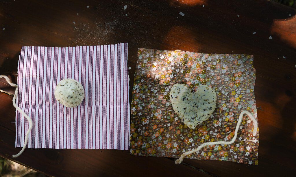 Zwei selbstgemachte Seifen liegen auf bunten Stoffquadraten 