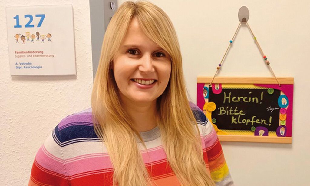 Porträt von Alina Votruba mit gestreiftem Pullover vor Zimmertür