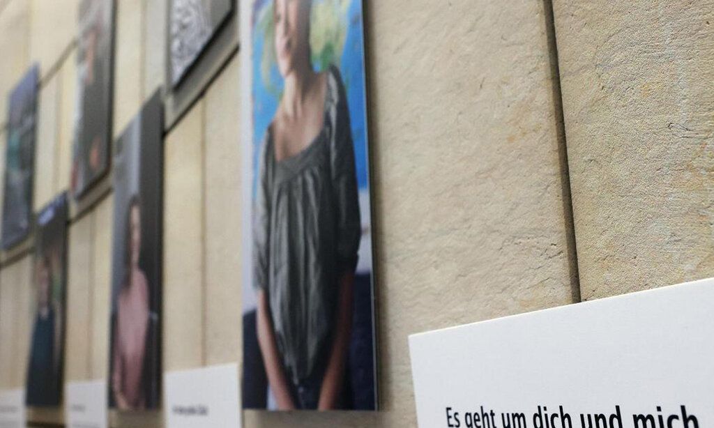 Porträtbilder von Frauen hängen an einer Wand, Ausstellung über Mutterschaft im Landtag NRW