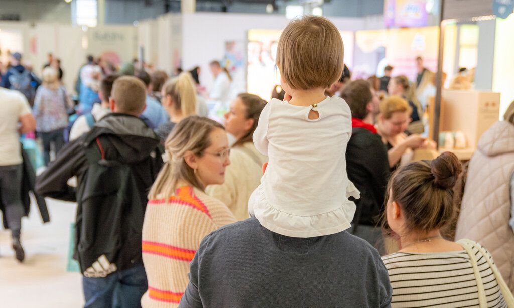 Besucher von hinten bei Babini Messe, Mann trägt Kind auf den Schultern