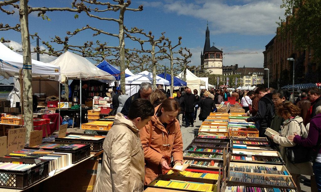 Büchermeile auf der Rheinpromenade, Besucher:innen stöbern in Bücherkisten