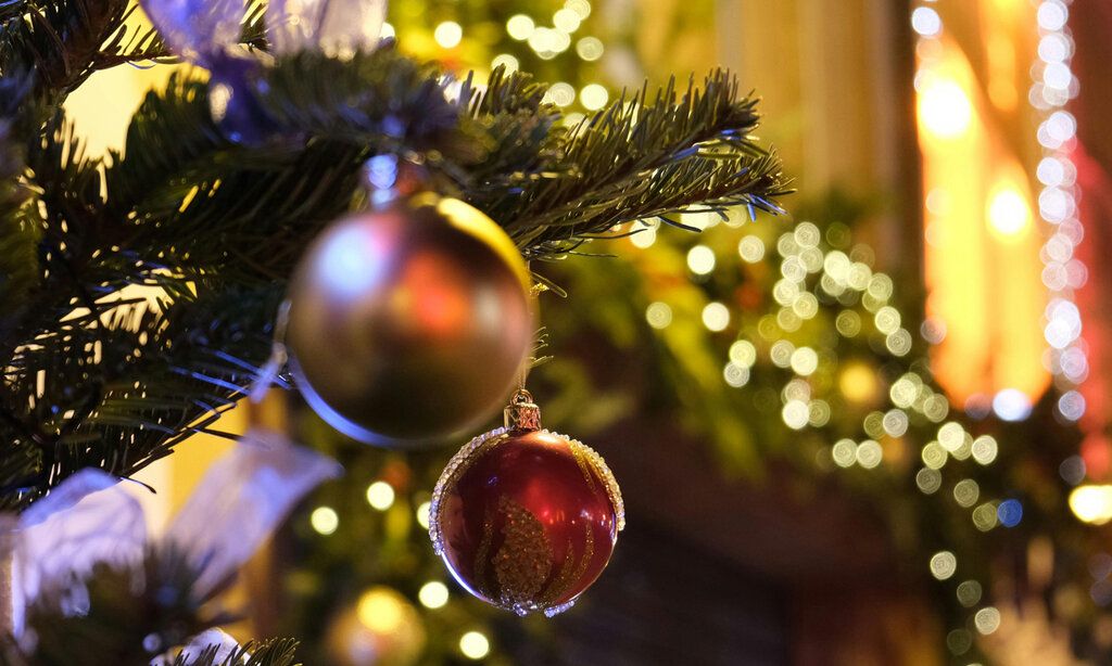 Christbaumkugeln am Baum, im Hintergrund verschwommene Lichter