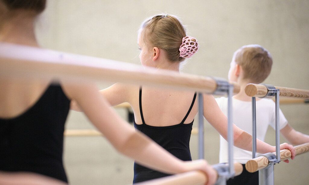 Drei Kinder tanzen an der Ballettstange