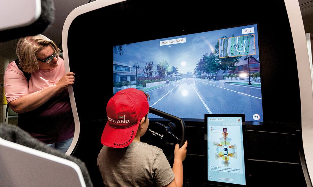 Junge sitzt an einem Fahr-Simulator