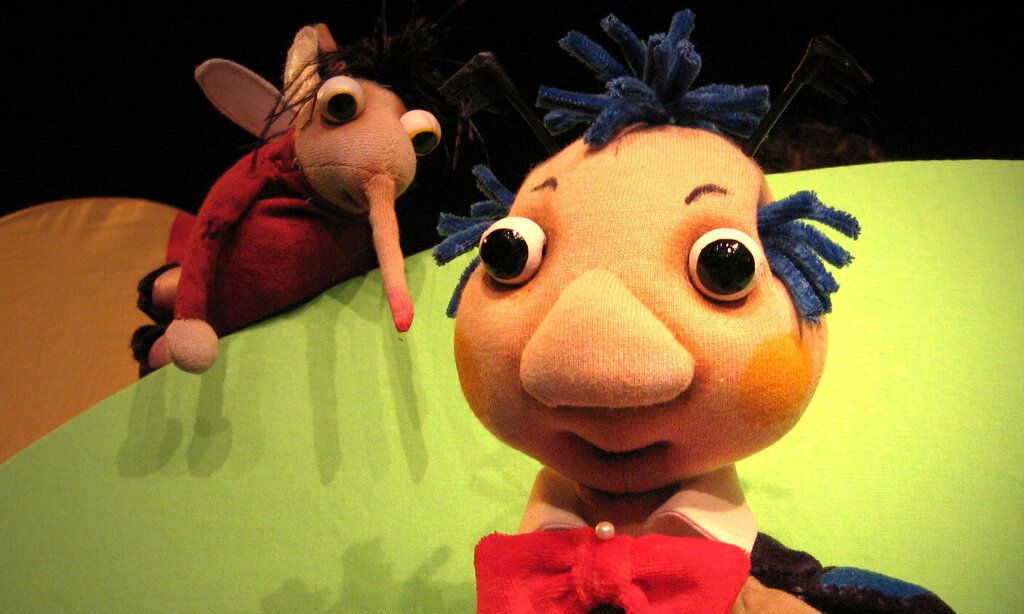 Zwei Puppefiguren, ein Käfer und ein Mann auf Puppenbühne