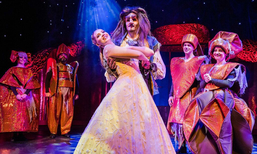 Schauspieler auf der Bühne, die Schöne und das Biest tanzen gemeinsam