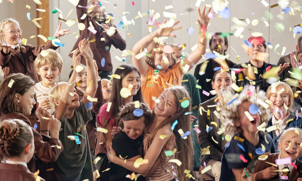 Gruppe von Schülern und Schülerinnen im Konfettiregen