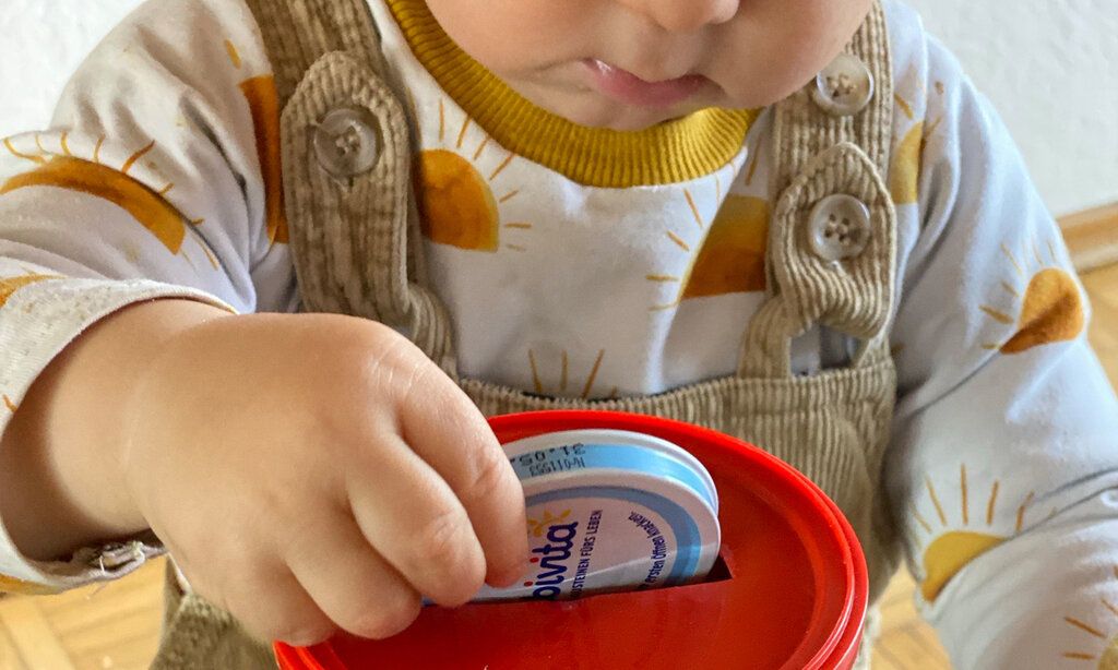 Baby spielt mit Deckeln