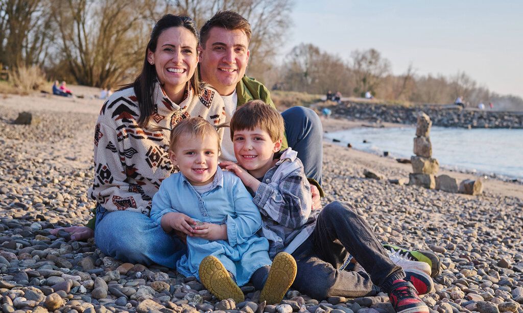 Porträt der Familie Hefer-Davis, Mutter, Vater und zwei Kinder sitzen am Rhein in Himmelgeist