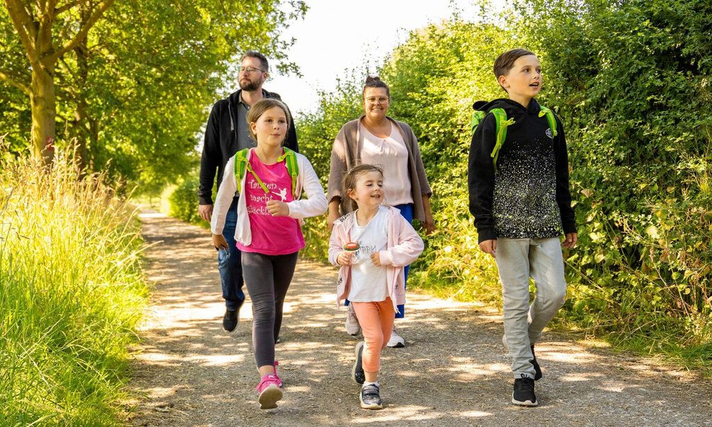 Vater, Mutter und drei Kinder wandern im Neandertal