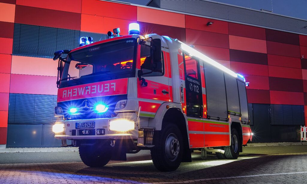 ein Feuerwehrwagen steht abends vor dem Gebäude der Freiwilligen Feuerwehr Düsseldorf-Garath
